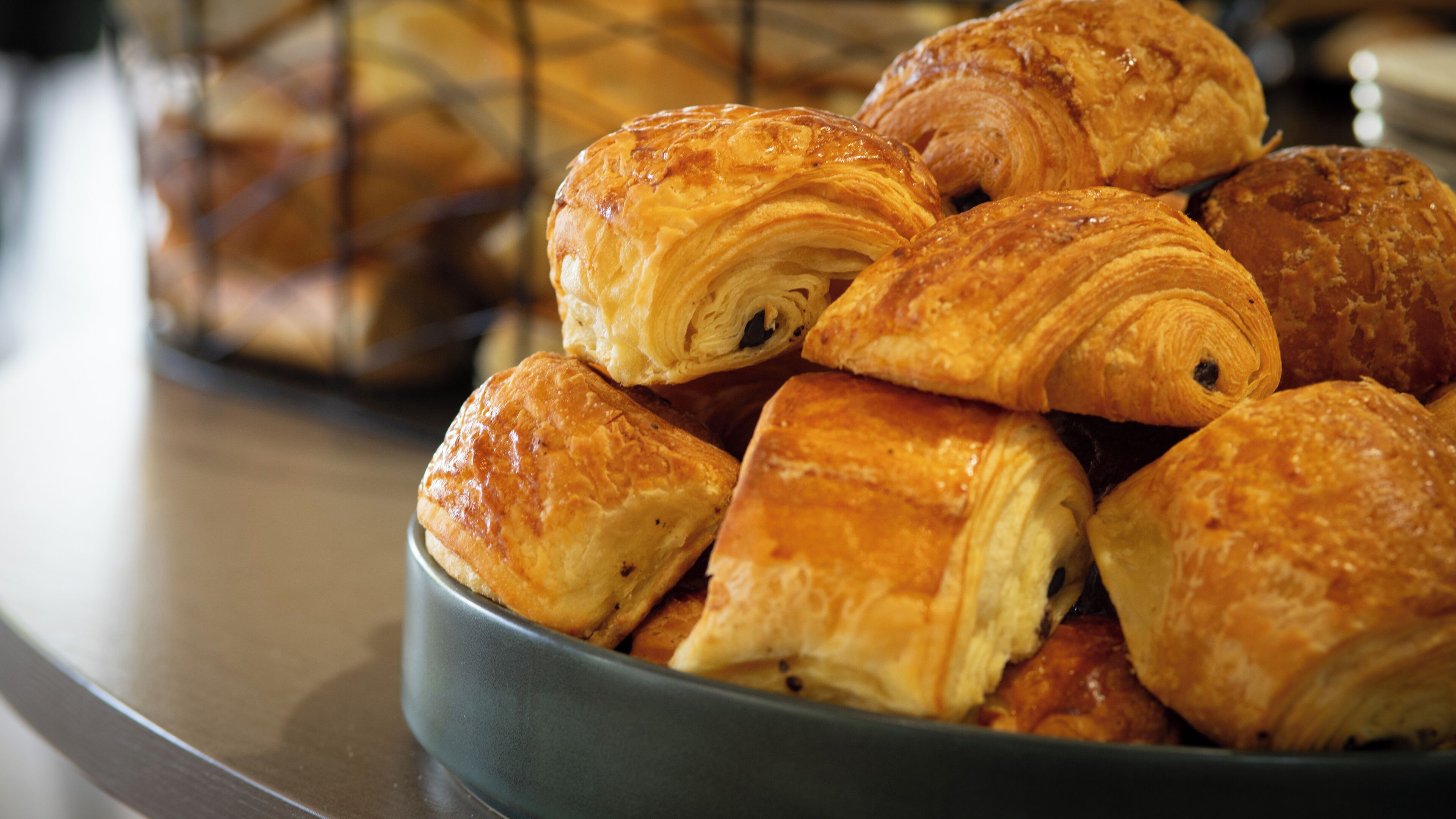 A bowl of assorted pastries, including croissants and other baked goods.
