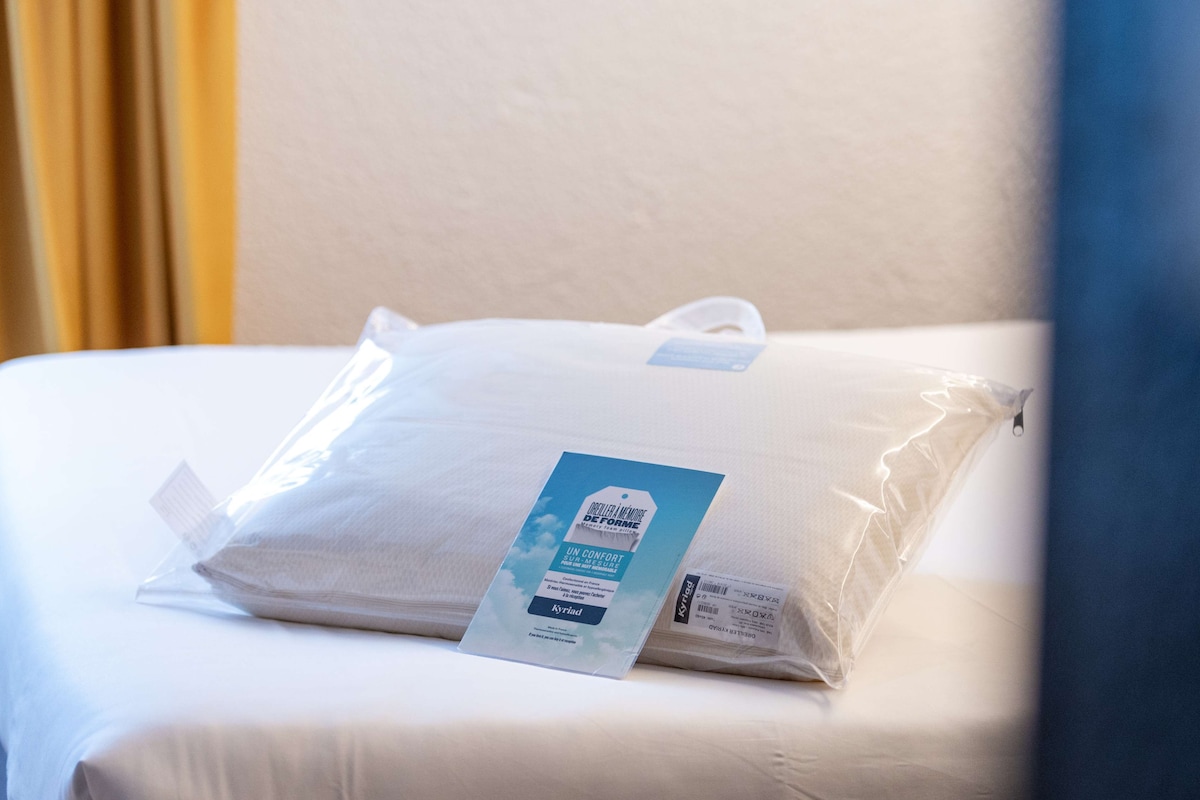A neatly made bed with a pillow and a pillowcase in a hotel room.