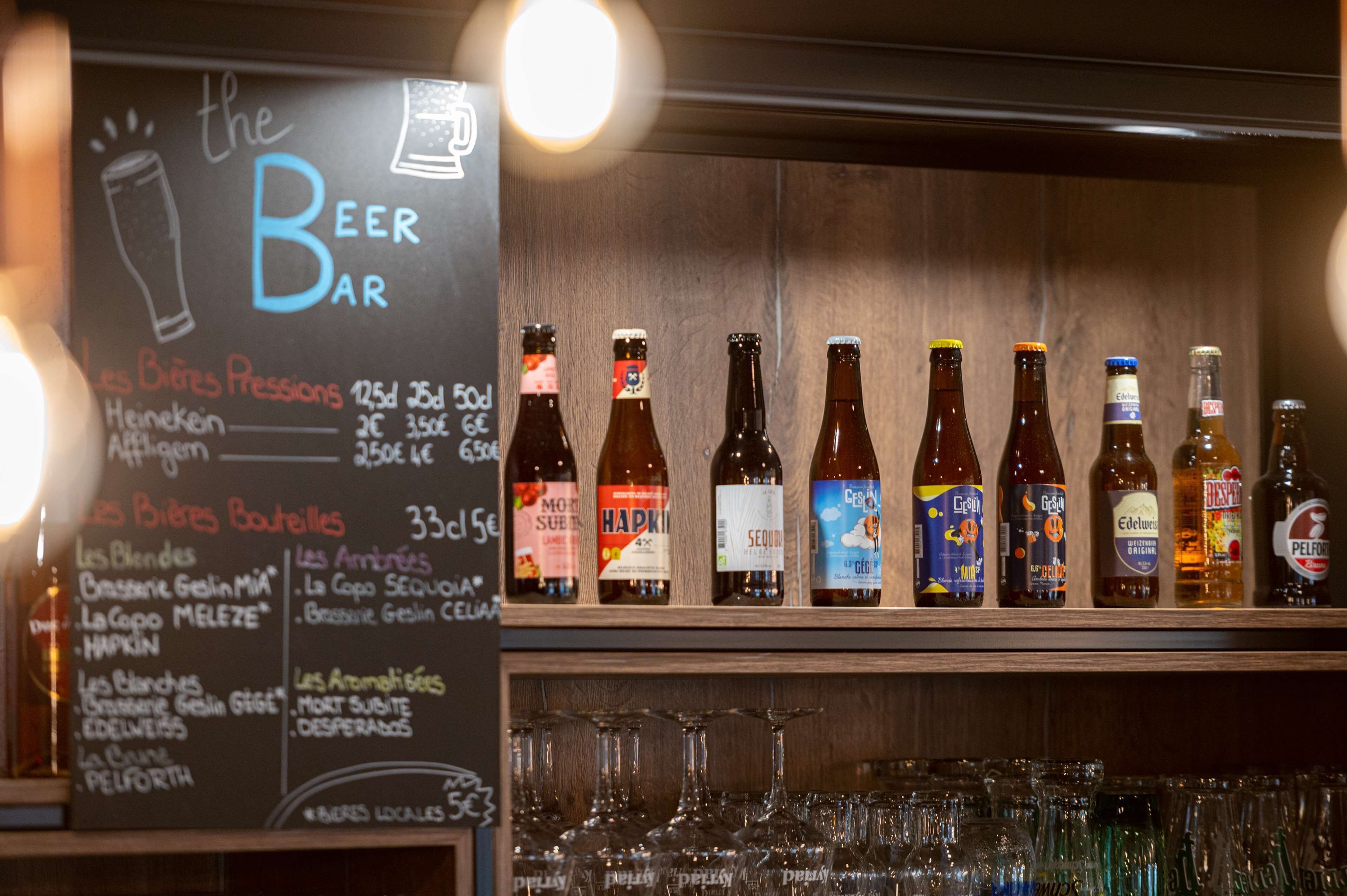Eine Bar mit einer Kreidetafel, die verschiedene Biersorten und Gläser auflistet.