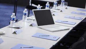A conference room with a long table, laptops, water bottles, and nameplates.