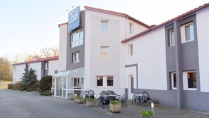 Ett hotell med modern design, med en inglasad innergård och utomhusmöbler.