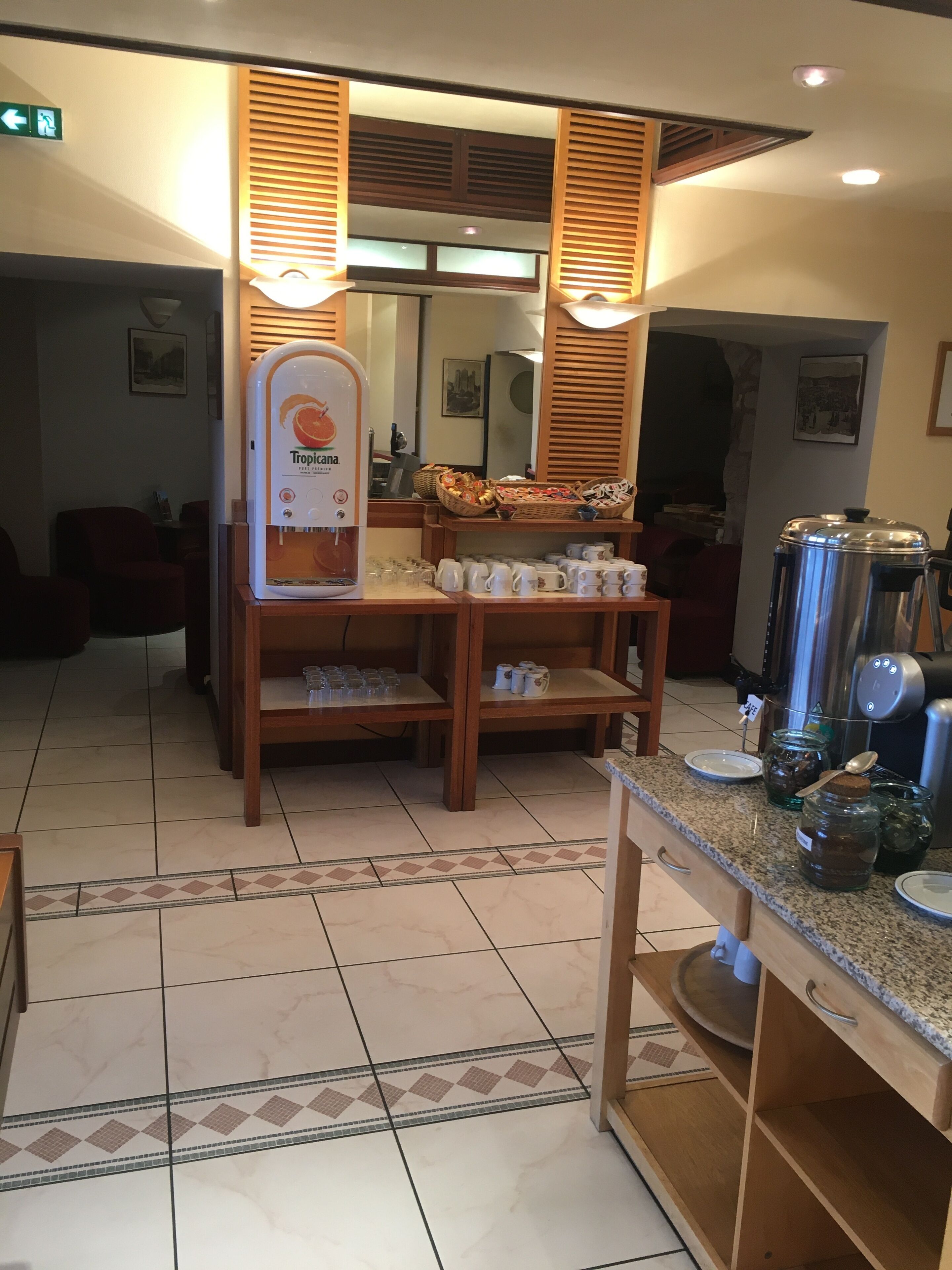 Habitación de hotel con kitchenette, minibar, exhibición de frutas y cafetera.