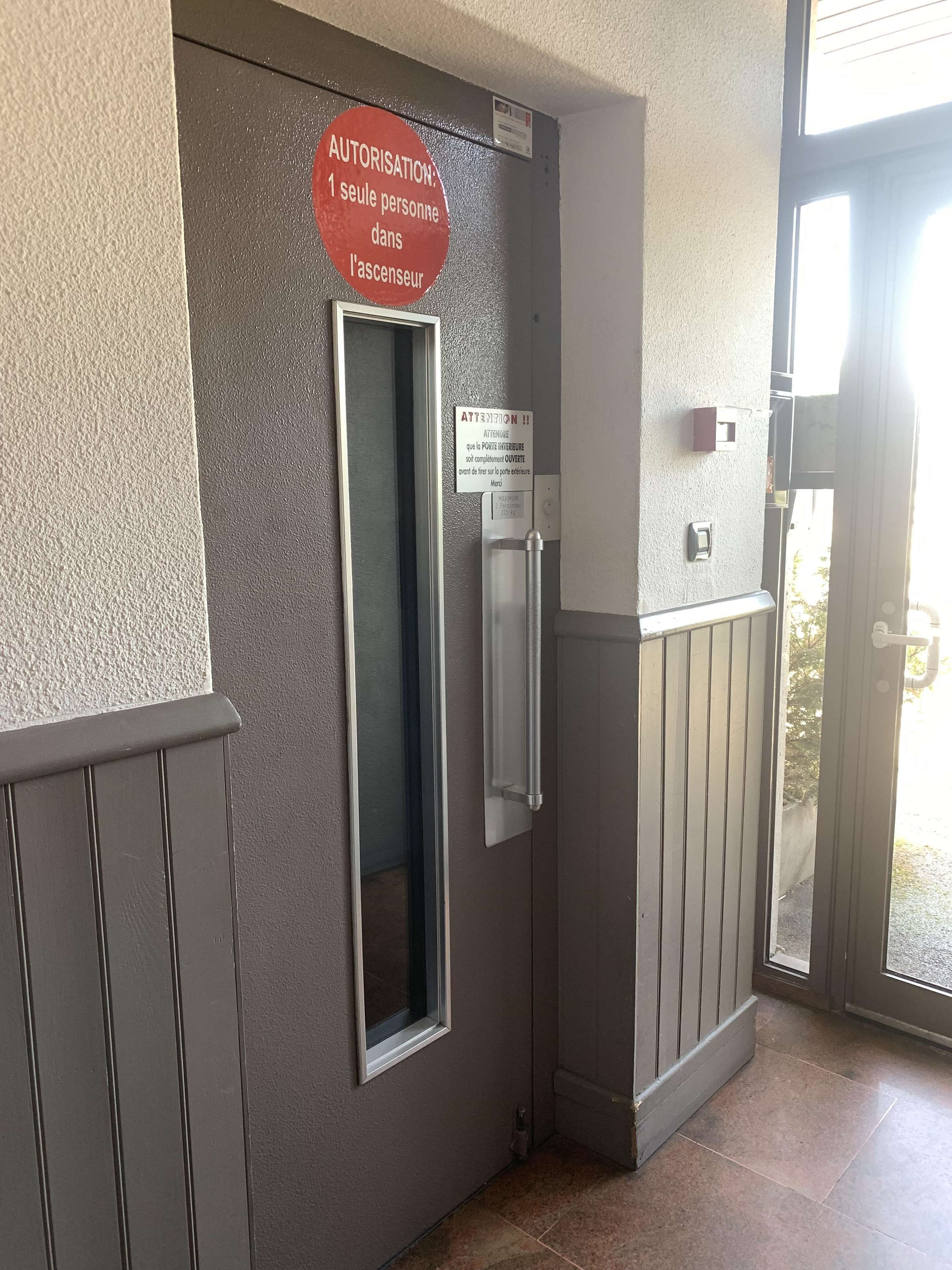 Una puerta con un letrero que indica que solo se permite el acceso de una persona al ascensor.