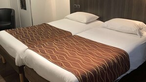 A double bed with a brown patterned bedspread, a wooden headboard, and a small bedside table. - Hotel Kyriad Rodez (Rodez)