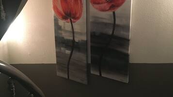 Duas pinturas de flores vermelhas em uma parede.