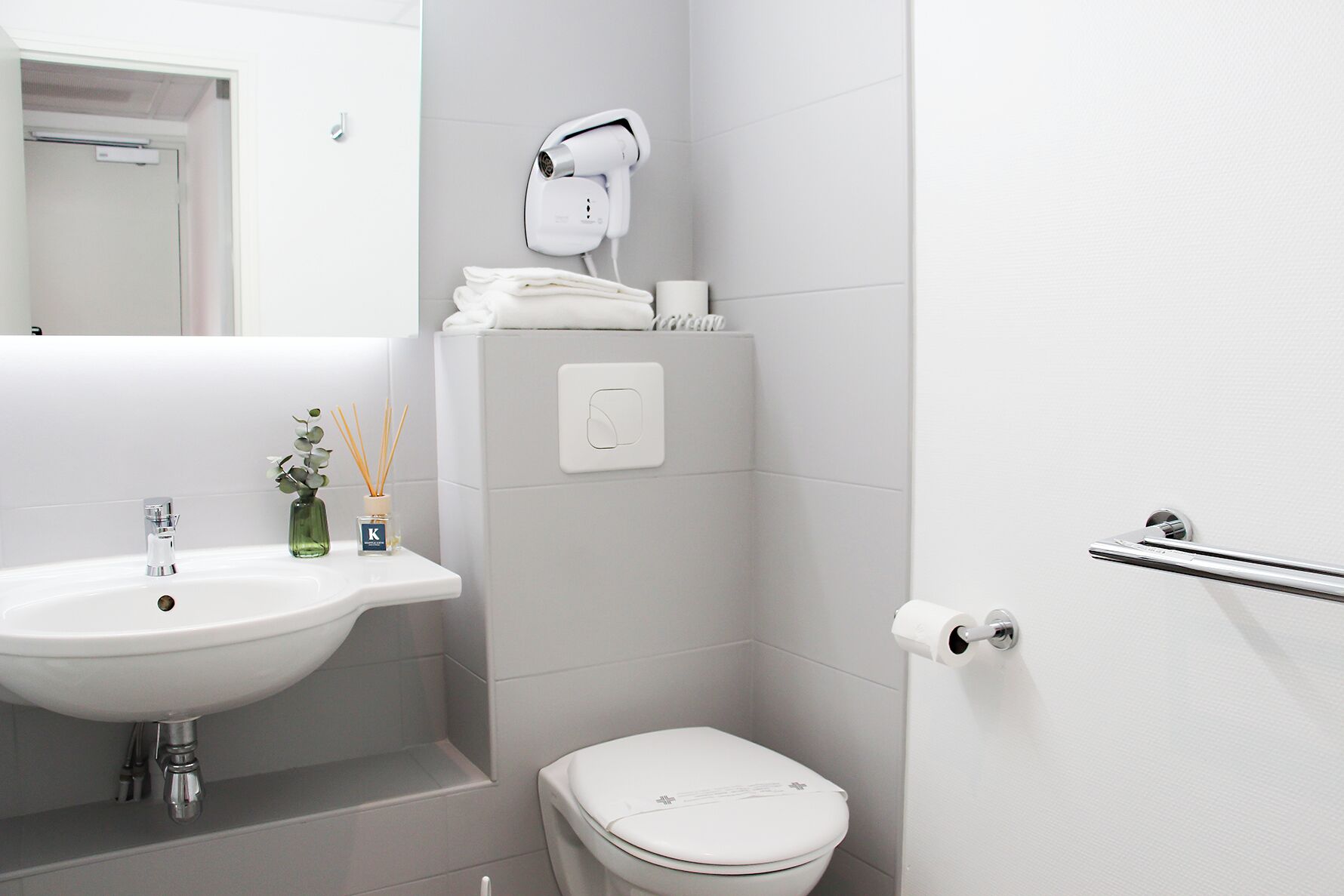 Ein modernes Badezimmer mit Waschbecken, Toilette und Handtuchhalter.