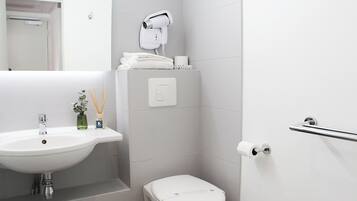 Ein modernes Badezimmer mit Waschbecken, Toilette und Handtuchhalter.