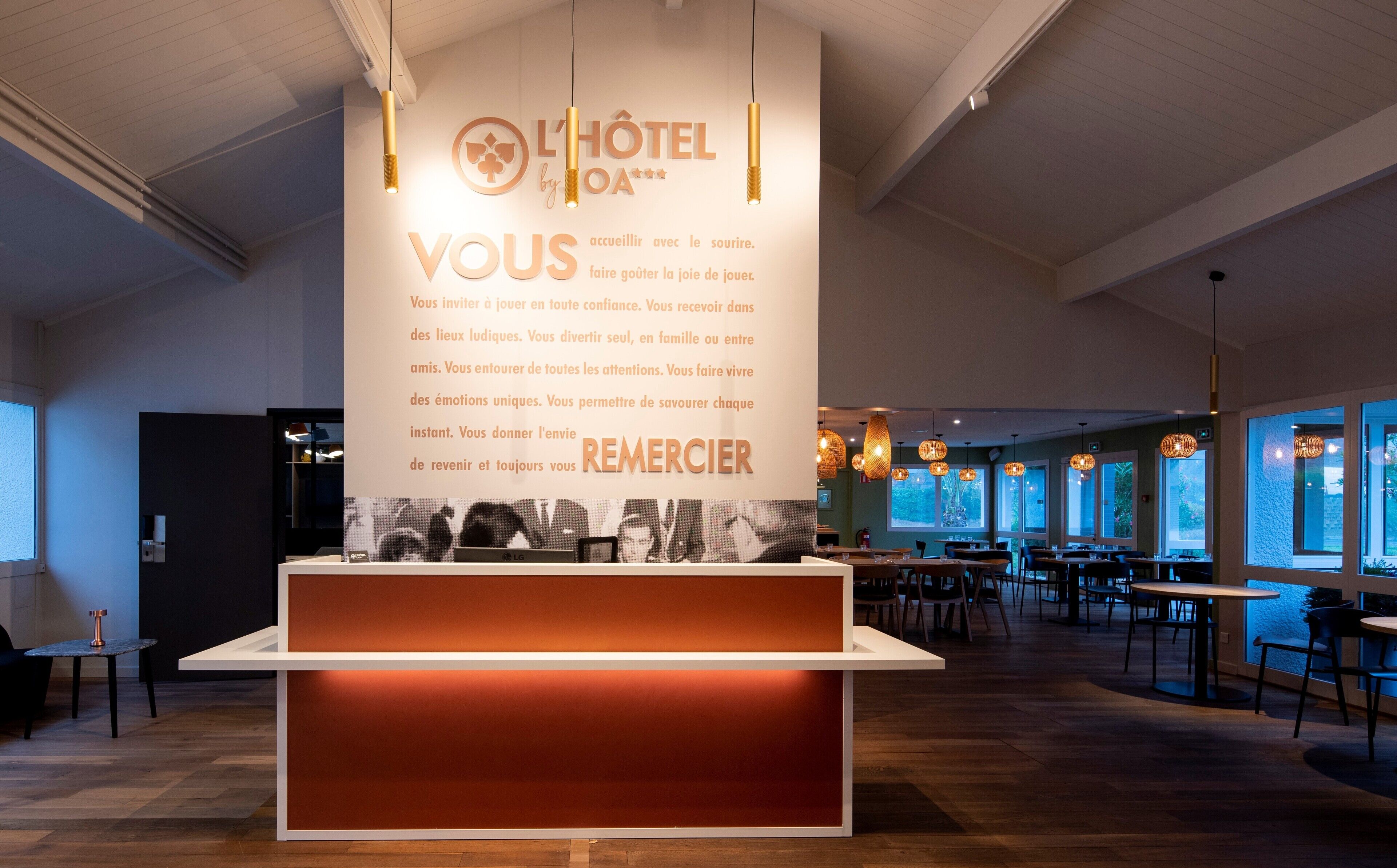 A hotel reception area with a modern design, featuring a large sign with the hotel's name and a welcoming message.