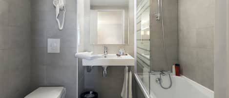 A modern bathroom with a toilet, sink, and shower.