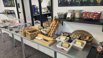 A buffet setup with various food items and a coffee machine.