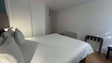 Ein Schlafzimmer mit Bett, einem Sessel und einem Kleiderschrank.