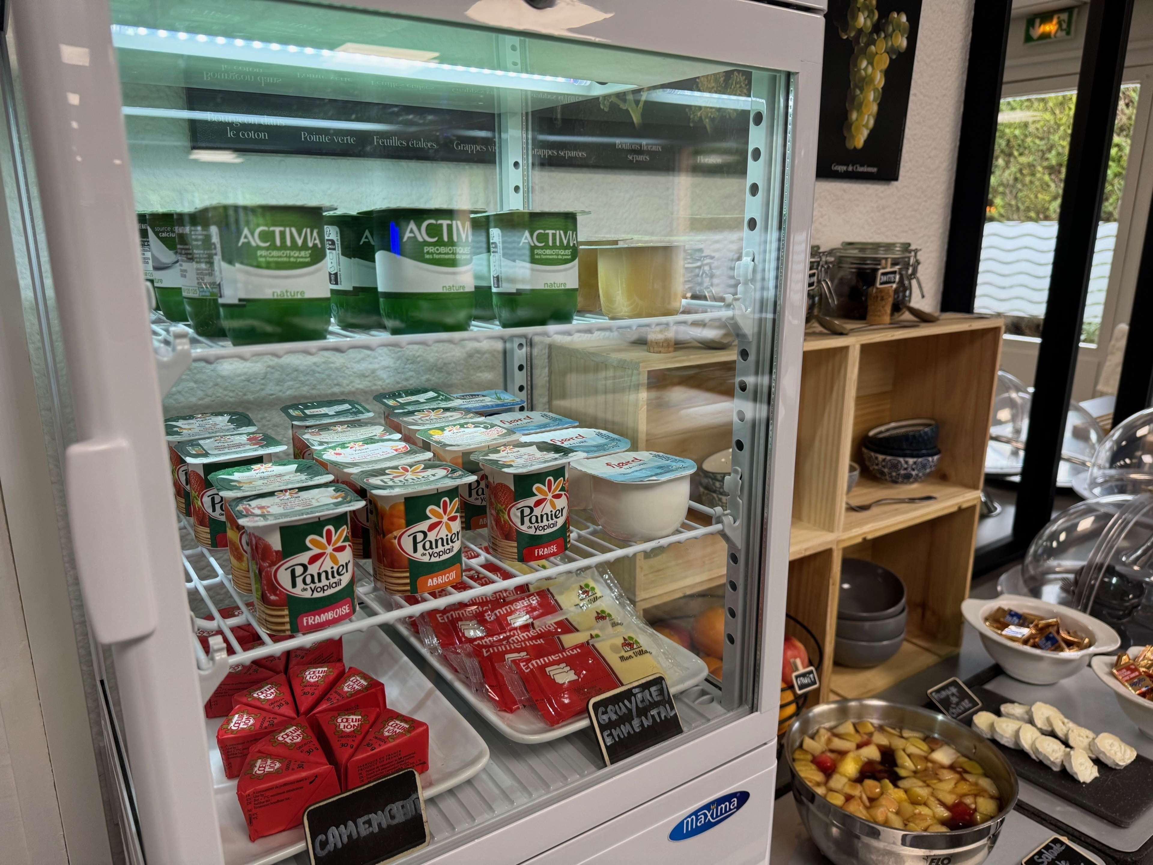 A refrigerated display case with various dairy products, including yogurt and cheese.