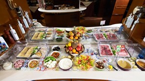 A buffet with various food items and condiments.