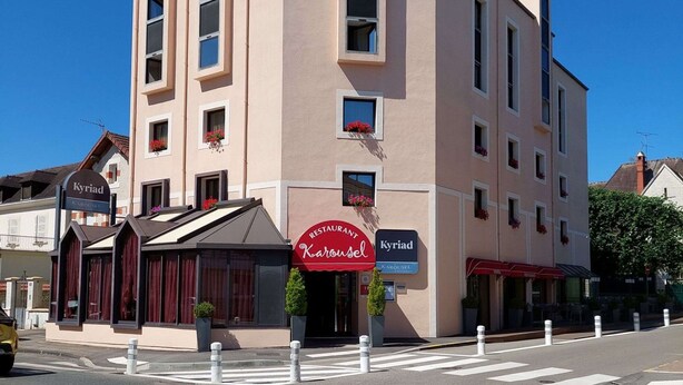 A multi-story hotel with a prominent sign for 'Karousel' restaurant.