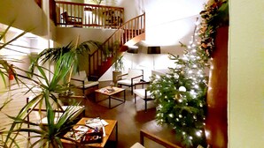 Àmplia zona d'estar amb una escala, un arbre de Nadal i diverses disposicions de seients.