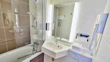 A modern bathroom with a glass-enclosed shower, a white sink, and a large mirror.