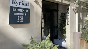 Entrada de un hotel con un letrero que indica 'Kyriad Batiment C' y los números de habitaciones 41 a 47, 51 a 58, y 61 a 68.