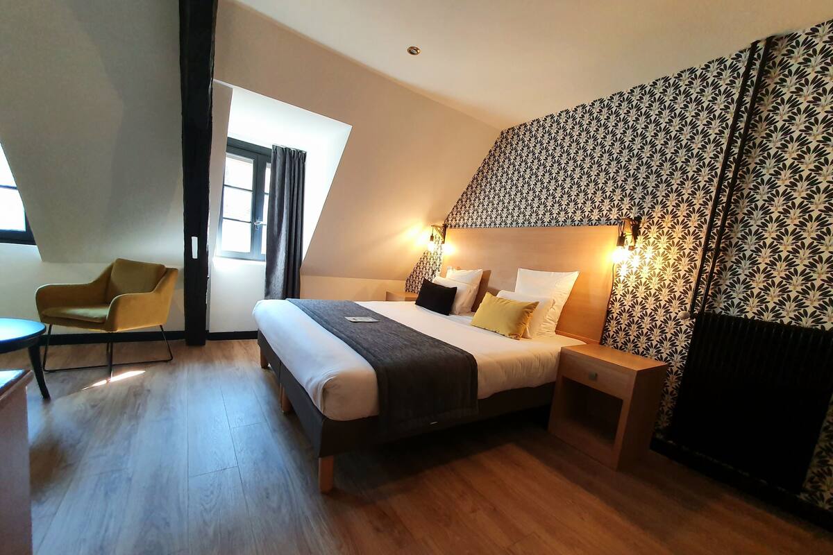 Ein modernes Schlafzimmer mit Bett, Stuhl und Fenster.