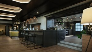 Une cuisine moderne dotée d’un îlot central, de tabourets de bar, de luminaires suspendus et d’un escalier menant à un niveau supérieur.