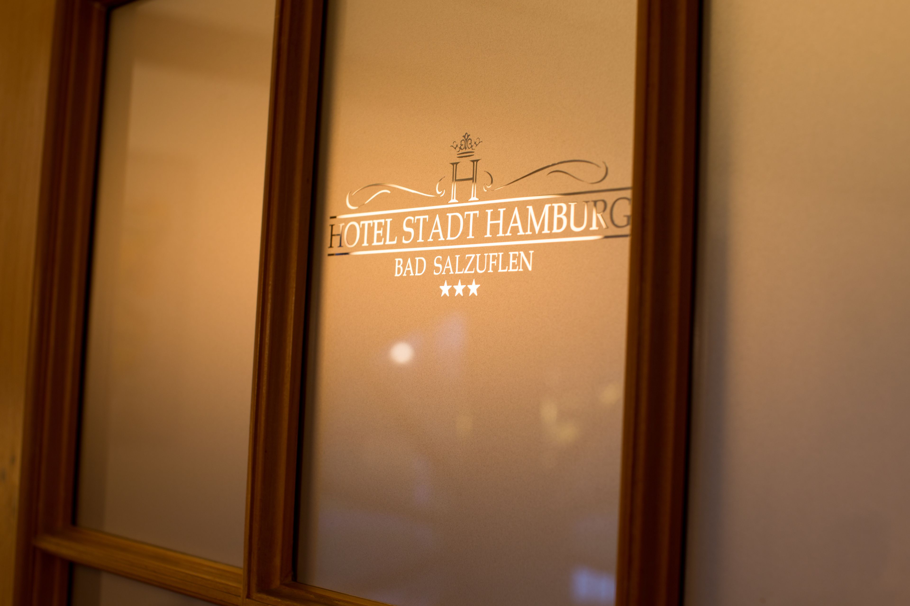 A framed sign with the text "HOTEL STADT HAMBURG BAD SALZUFEN" and three stars.