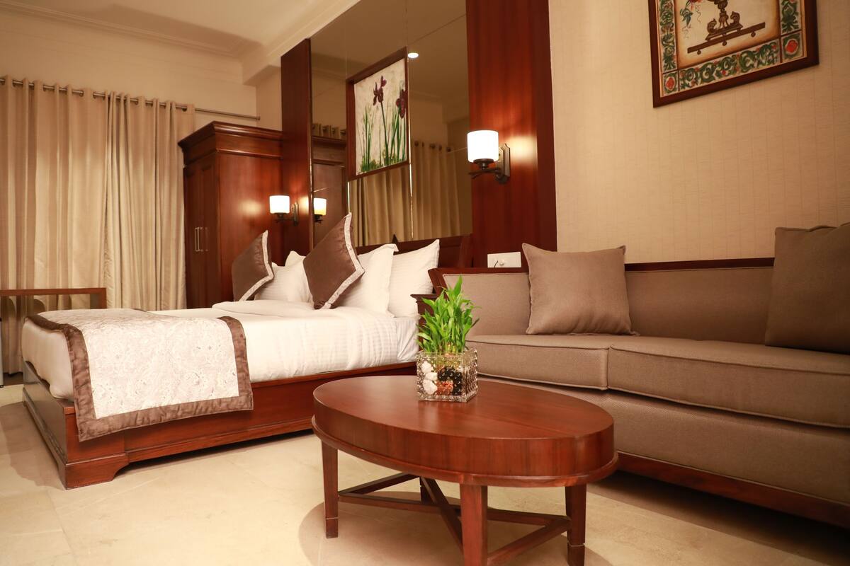 Una habitación de hotel con una cama, un sofá y una mesita de centro.