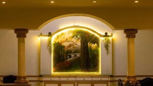 A lobby with a mural, columns, and a tiled floor. - Hotel Siddhartha Palace (Ahmedabad)