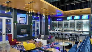 A modern lounge area with a bar, seating arrangements, and a fireplace.