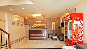 A hotel lobby with a reception desk, seating area, and a Coca-Cola vending machine. - Hotel Raj Darbar (Amritsar)