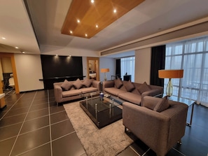 Ein modernes Wohnzimmer mit einer Sofagarnitur, einem Couchtisch und einem Flachbildfernseher.