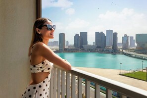 A balcony with a view of a city skyline and a body of water. - Hala Arjaan by Rotana (Abu Dhabi)