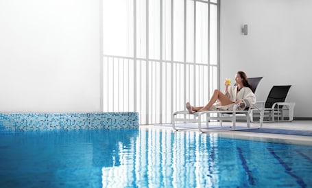 Una piscina techada, sillones reclinables de piscina