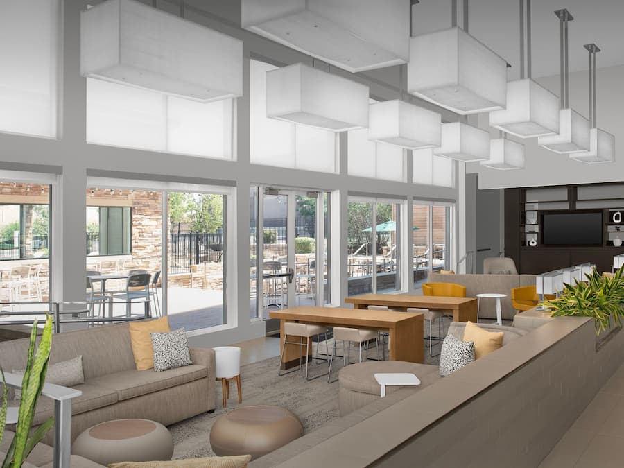 A modern interior with a seating area, large windows, and a kitchen area.