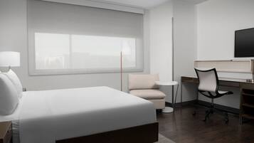 Une chambre d’hôtel moderne équipée d’un grand lit, d’un bureau, d’une chaise, d’une télévision et d’une fenêtre avec des stores.