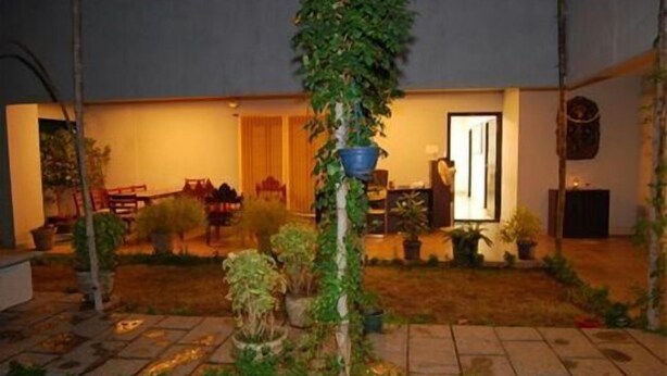 A courtyard with a dining area, a door, and potted plants. - Shylee Niwas Kodambakkam I (Chennai)