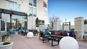 An outdoor seating area with a sofa, chairs, and a coffee table. - Aloft by Marriott Phoenix-Airport (Phoenix)