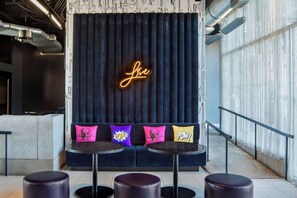 Eine Sitzecke mit einer Neonreklame, bequemen Sitzgelegenheiten und einem modernen Design.