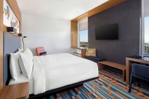A hotel room with a bed, a desk, a chair, a TV, and a window with a city view. - Aloft by Marriott Phoenix-Airport (Phoenix)