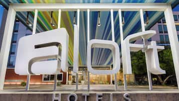 Een hotelentree met een modern ontwerp, met grote witte letters die 'HOTELS' op de grond vormen.