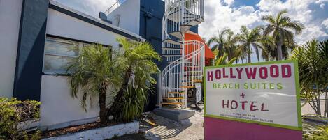 Un edificio moderno con un letrero que indica Hollywood Beach Suites Hotel.