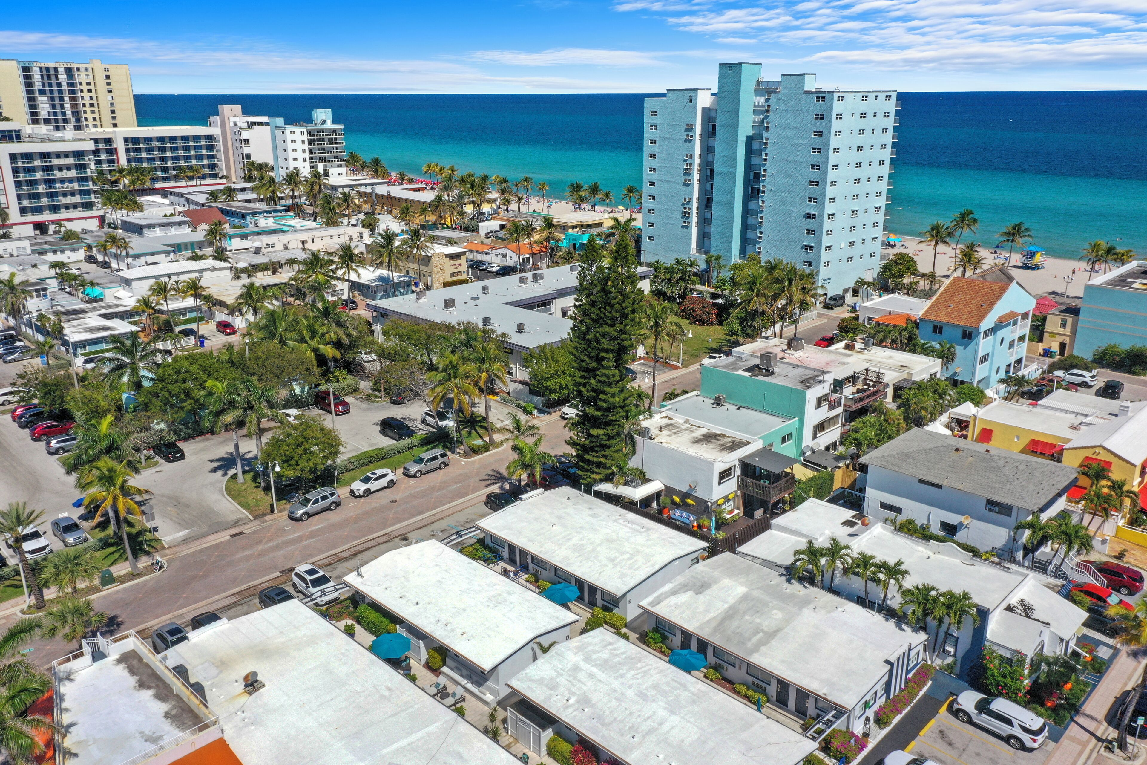 Paisagem costeira com edifícios altos, uma praia e uma combinação de edifícios residenciais e comerciais.