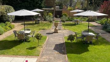 A garden patio area with outdoor seating and a central pathway.