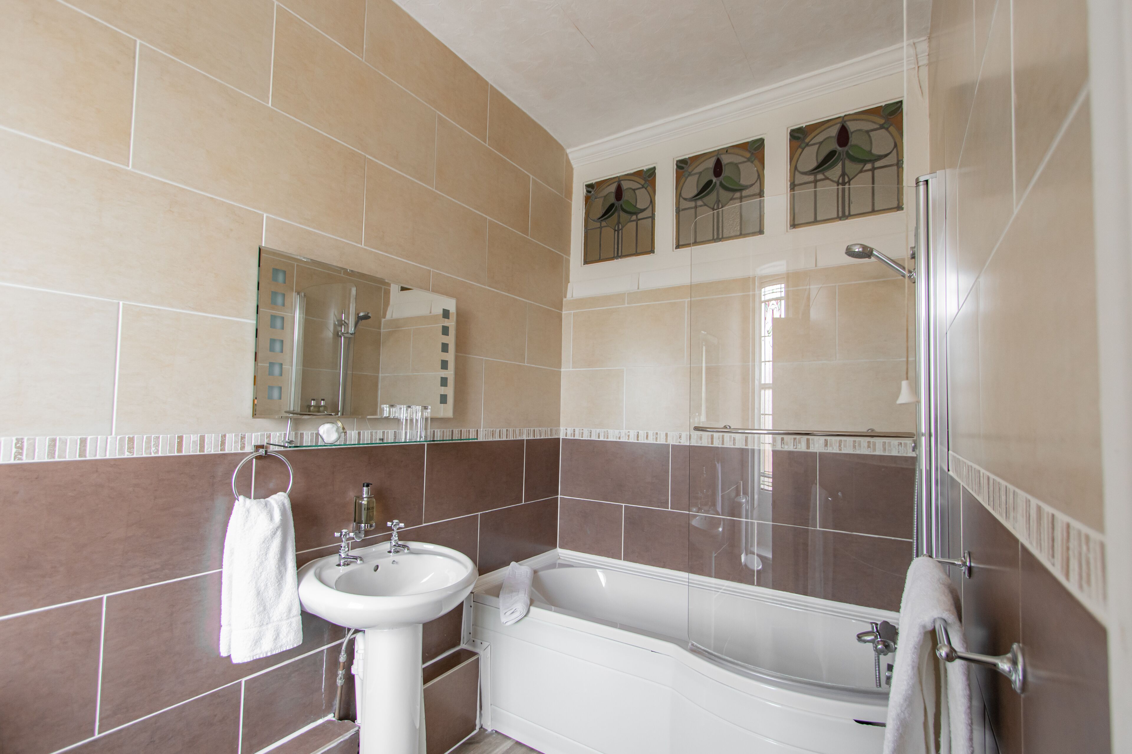Un baño con bañera, lavamanos y cabina de ducha de vidrio.
