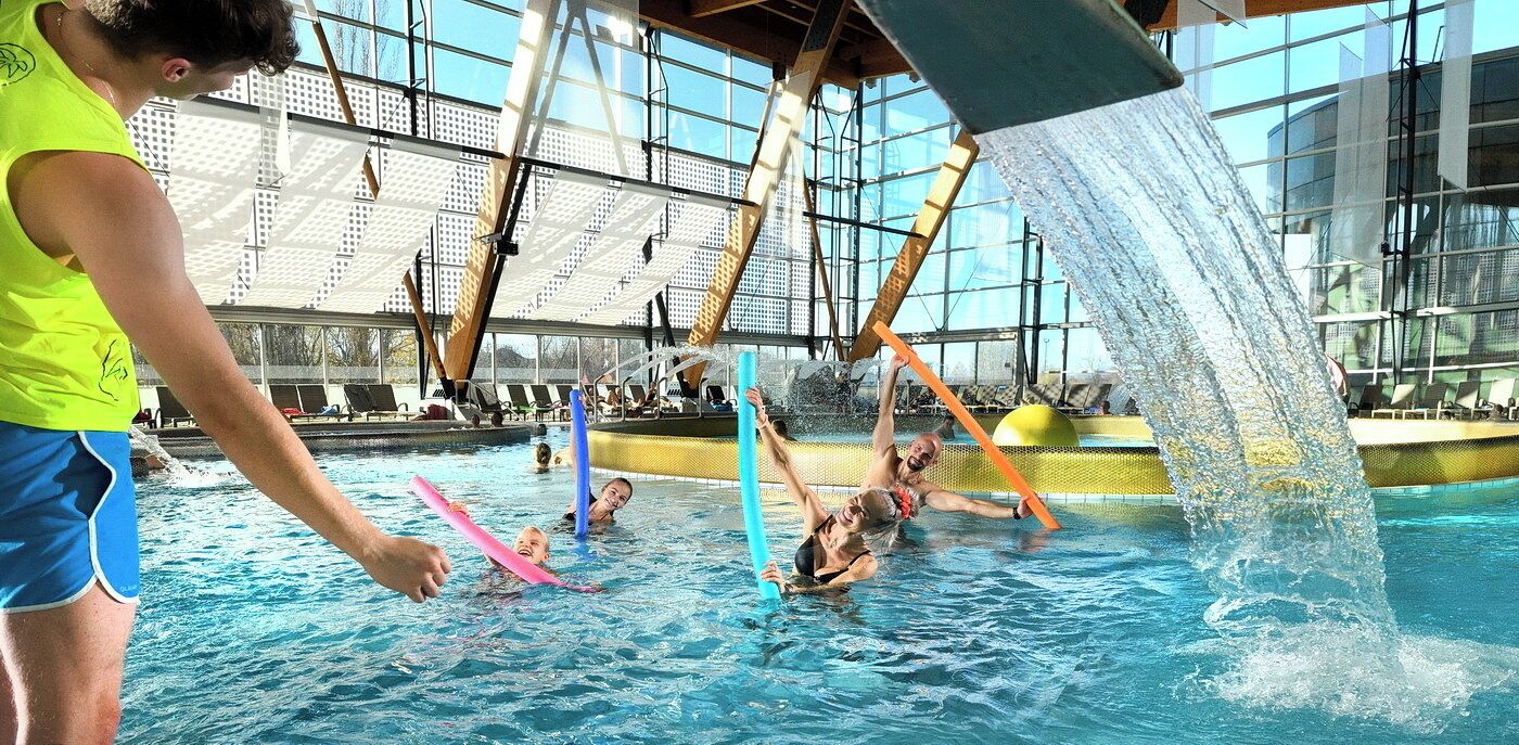 An indoor swimming pool with a clear view of the ceiling structure and a water feature.