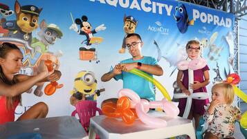 A group of people engaged in an activity with balloons and a backdrop featuring cartoon characters.