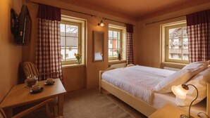 A cozy bedroom with a bed, bedside table, lamp, and a window with curtains. - Vitranc (Kranjska Gora)
