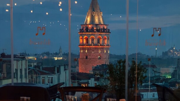 Um restaurante com vista para uma torre histórica.
