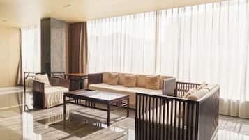 A modern living room with a sofa, armchairs, a coffee table, and a fireplace.