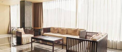 Una sala de estar moderna con sofá, sillones, una mesa de centro y chimenea.