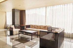 A modern living room with a sofa, armchairs, a coffee table, and a fireplace. - Jiangyin Life Island Hotel (Wuxi)