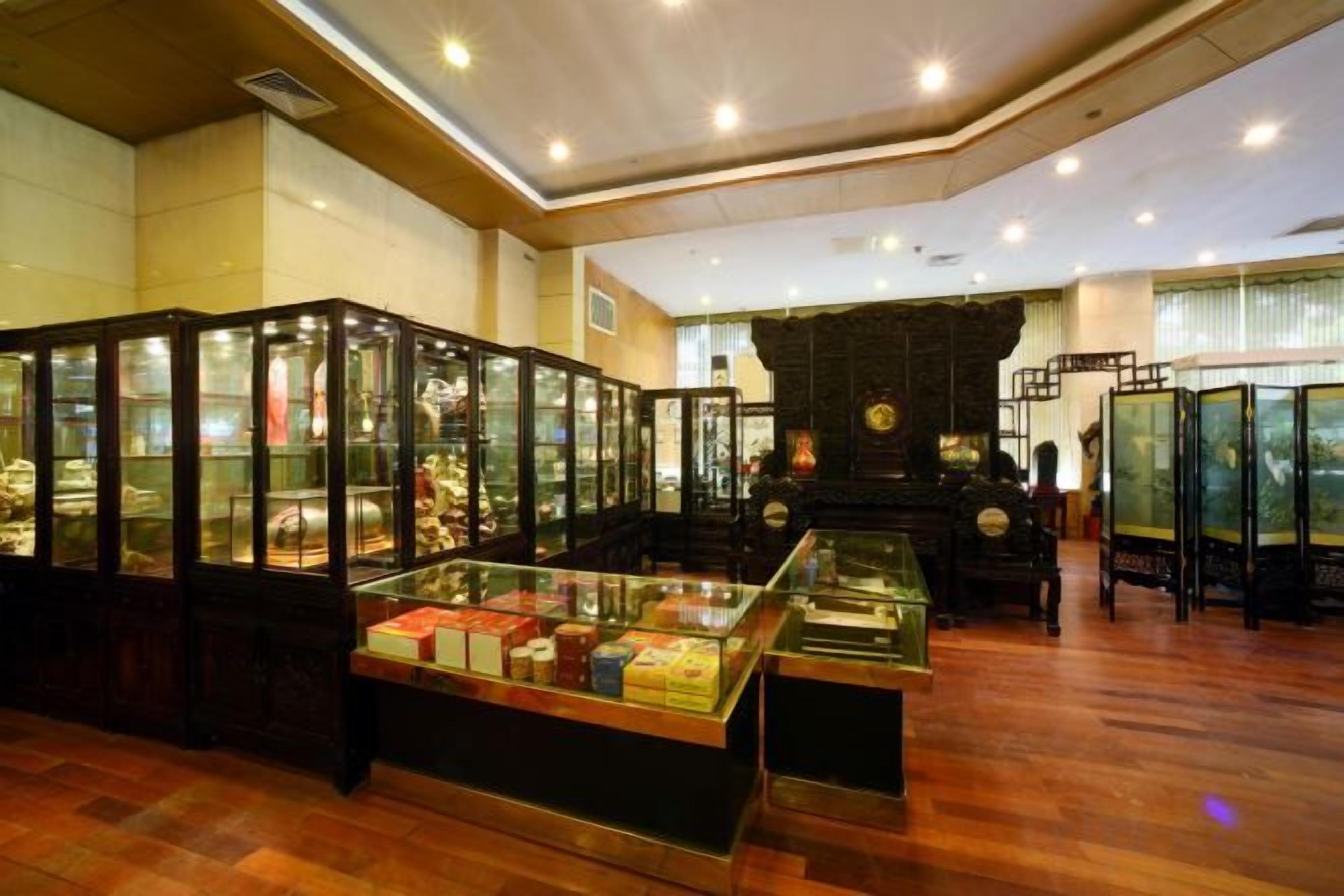 A room with a wooden floor, glass display cases, and a fireplace.